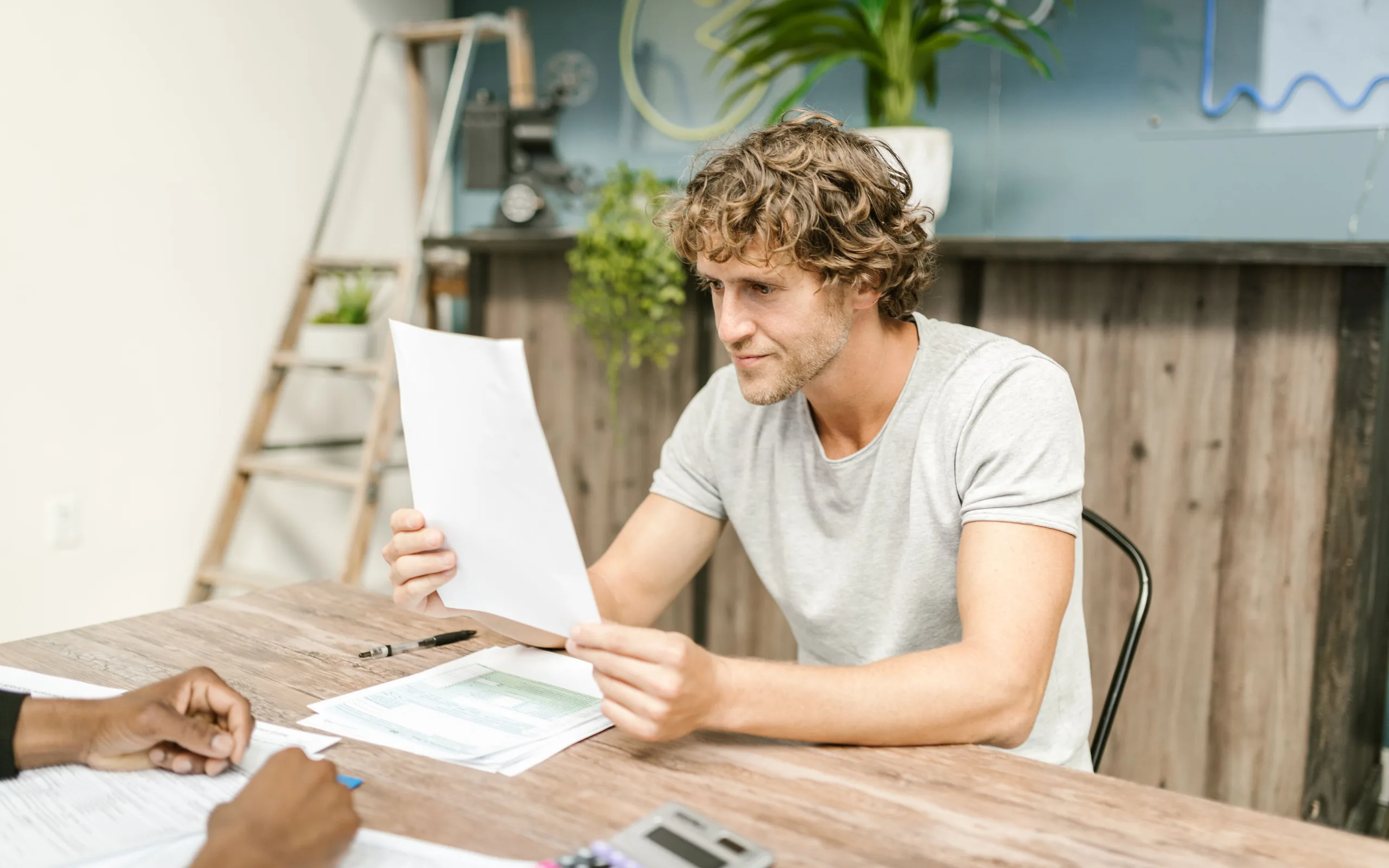 Un homme relit attentivement des documents d’assurance à son bureau